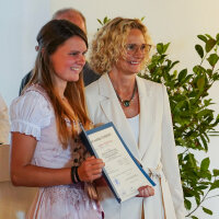 Übergabe des Facharbeiterbriefs an eine Absolventin