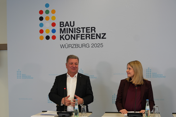 Bayerns Bauminister Christian Bernreiter und Bundesbauministerin Verena Hubertz stehen an Rednerpulten
