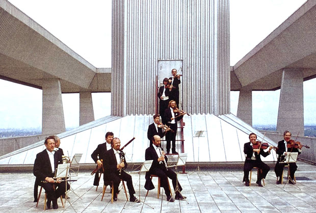 Ein Orchester spielt auf einem futuristischen Dach