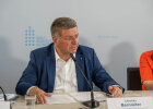 Bauminister Christian Bernreiter spricht an einem Konferenztisch in ein Mikrofon